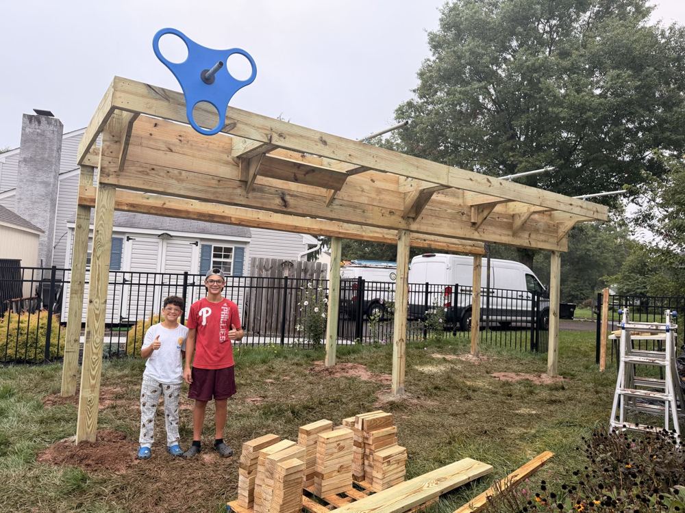 Two kids giving a thumbs up in front of a new ninja rig frame