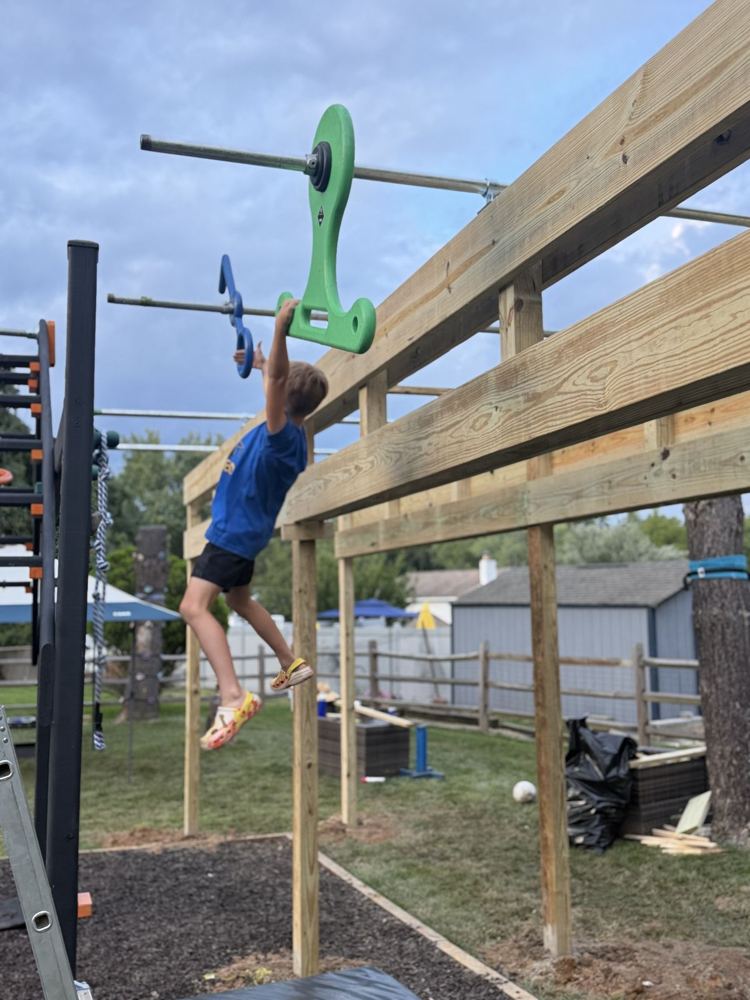 Kid hanging from a grip on a newly built rig